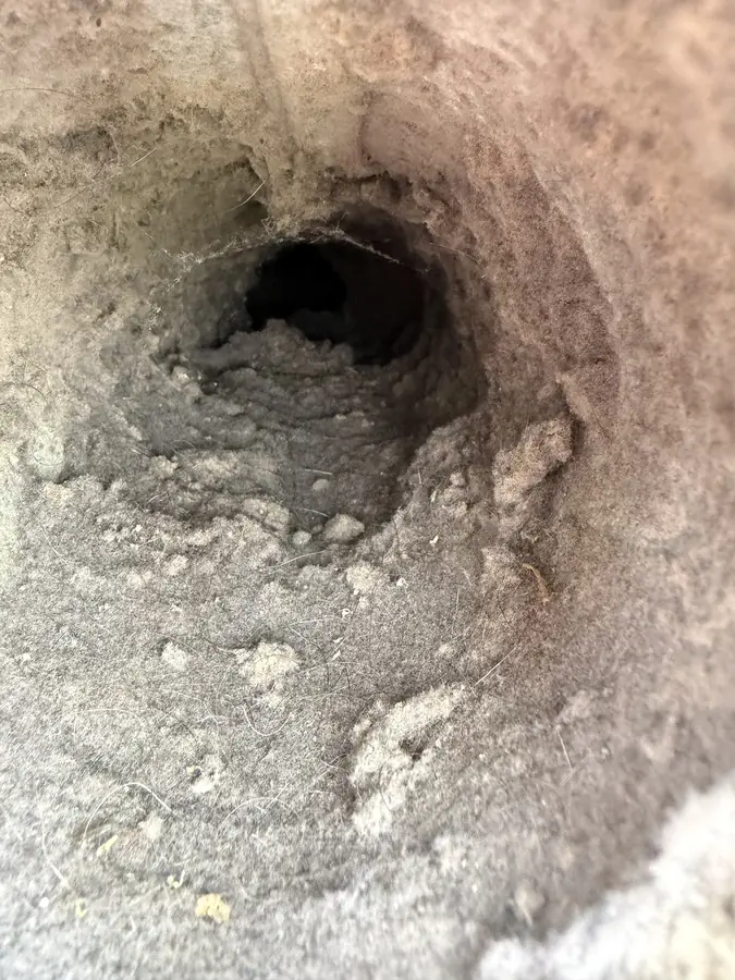 Clogged dryer vent packed with lint during airflow service