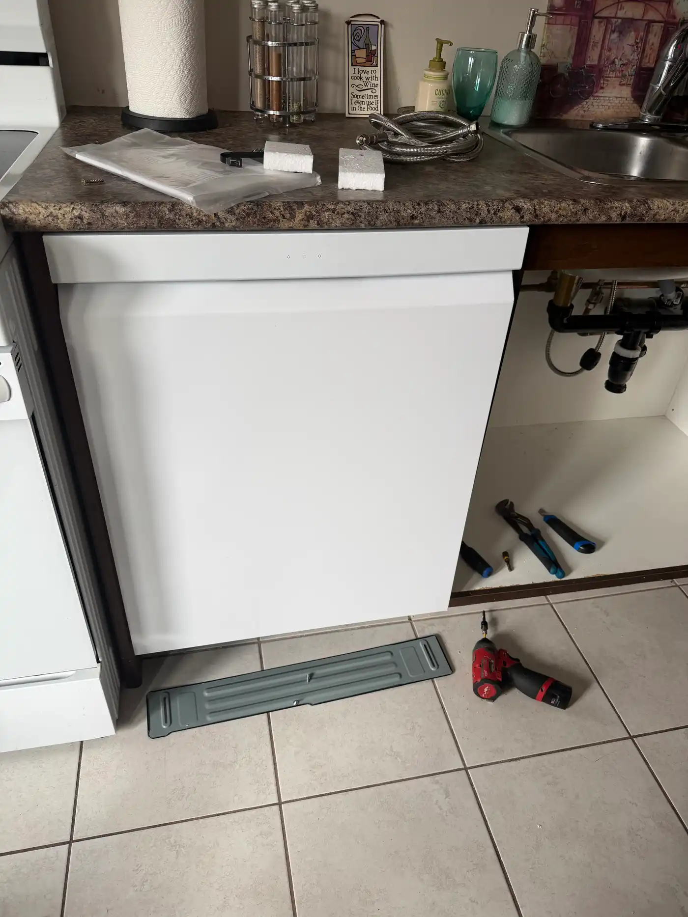 Dishwasher fitted under the counter with supply lines connected during installation in Ottawa