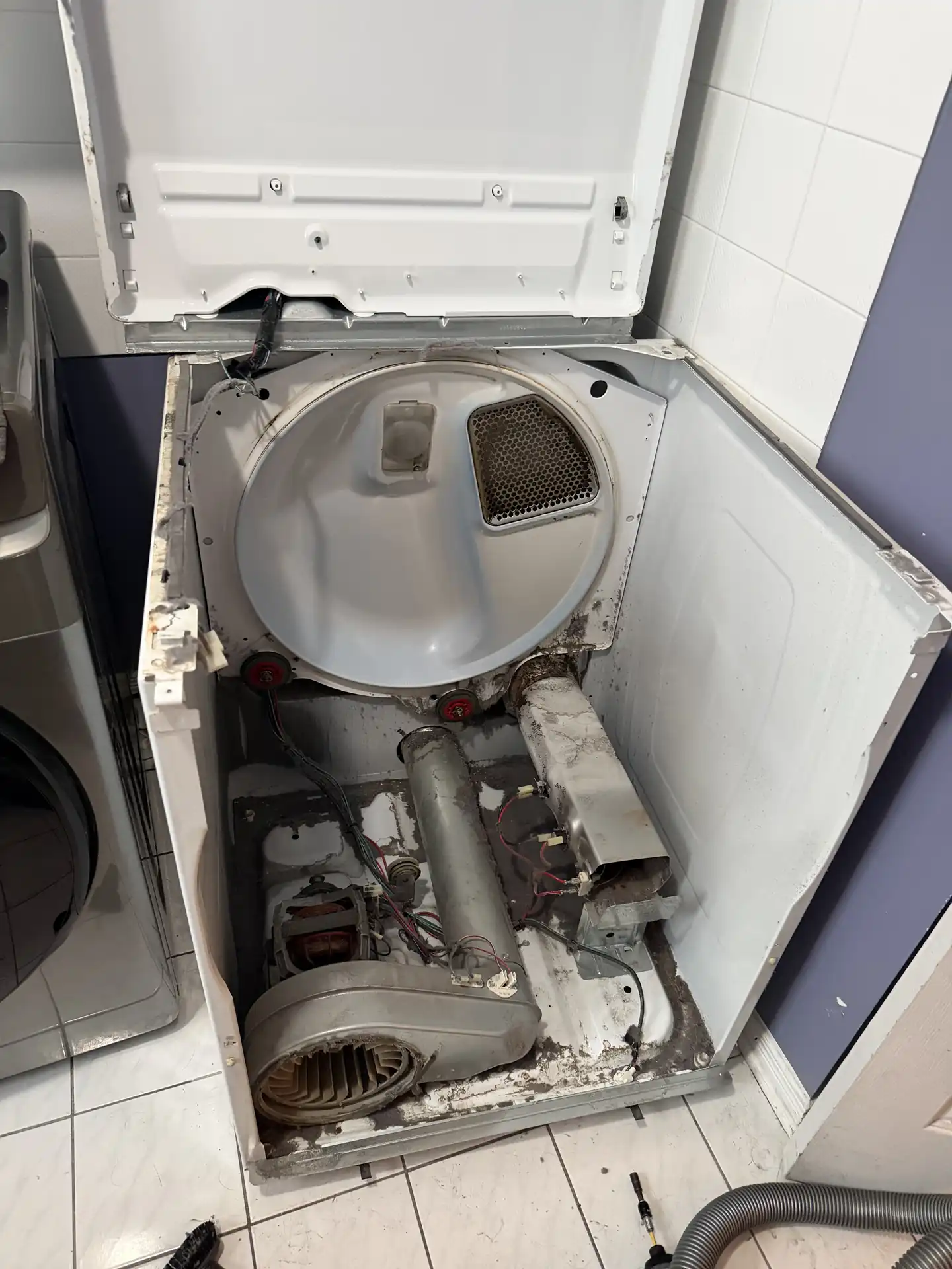 Dryer opened from the back showing the blower, motor, and heating element during repair in Ottawa