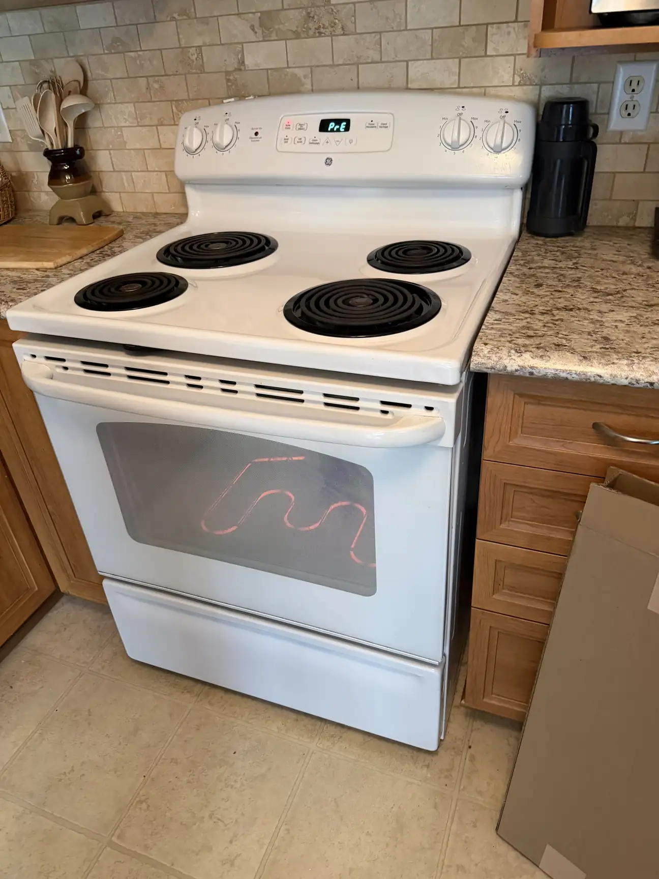 Oven with glowing bake element seen through the door during testing