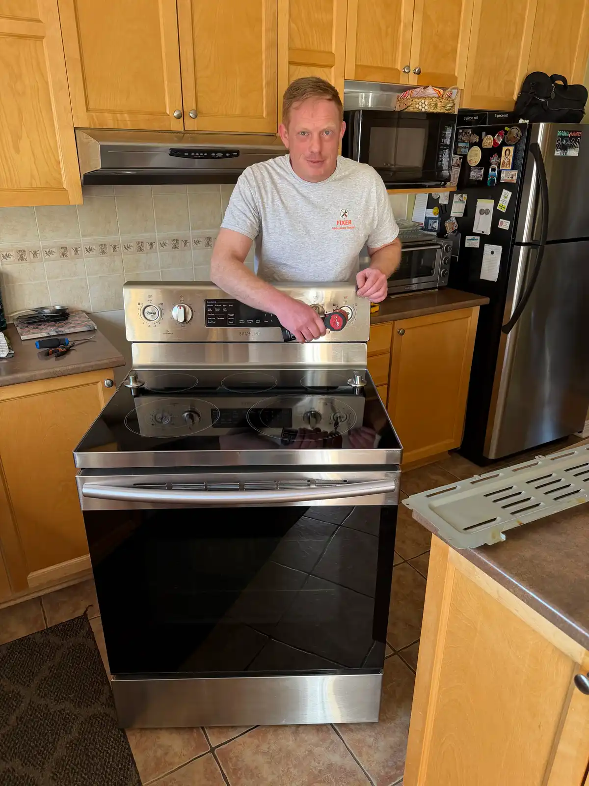 Technician repairing the control panel of a Samsung range in Ottawa