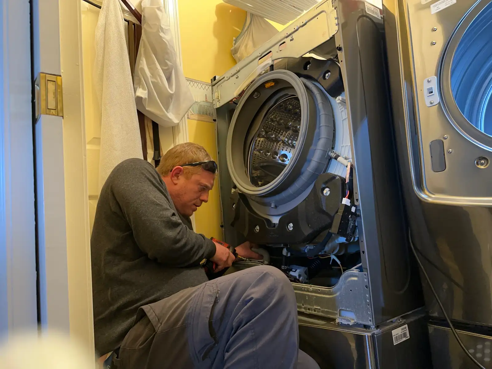 Fixer technician repairing a front-load washer in an Ottawa home