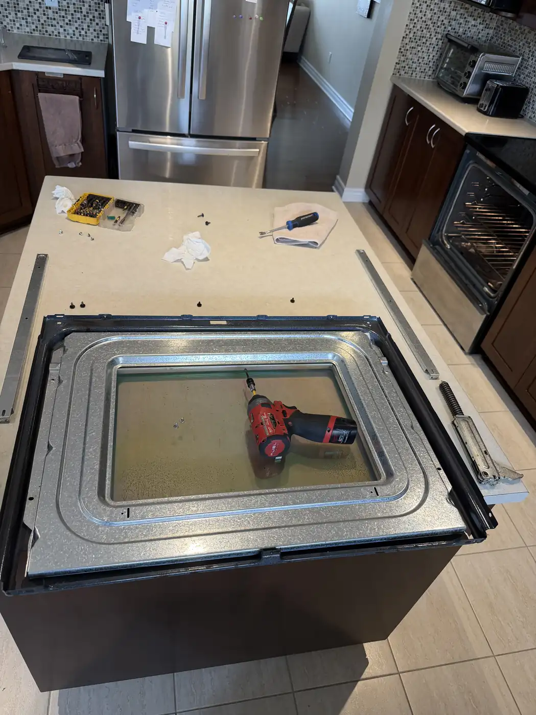 Oven door removed and laid out during repair in an Ottawa kitchen