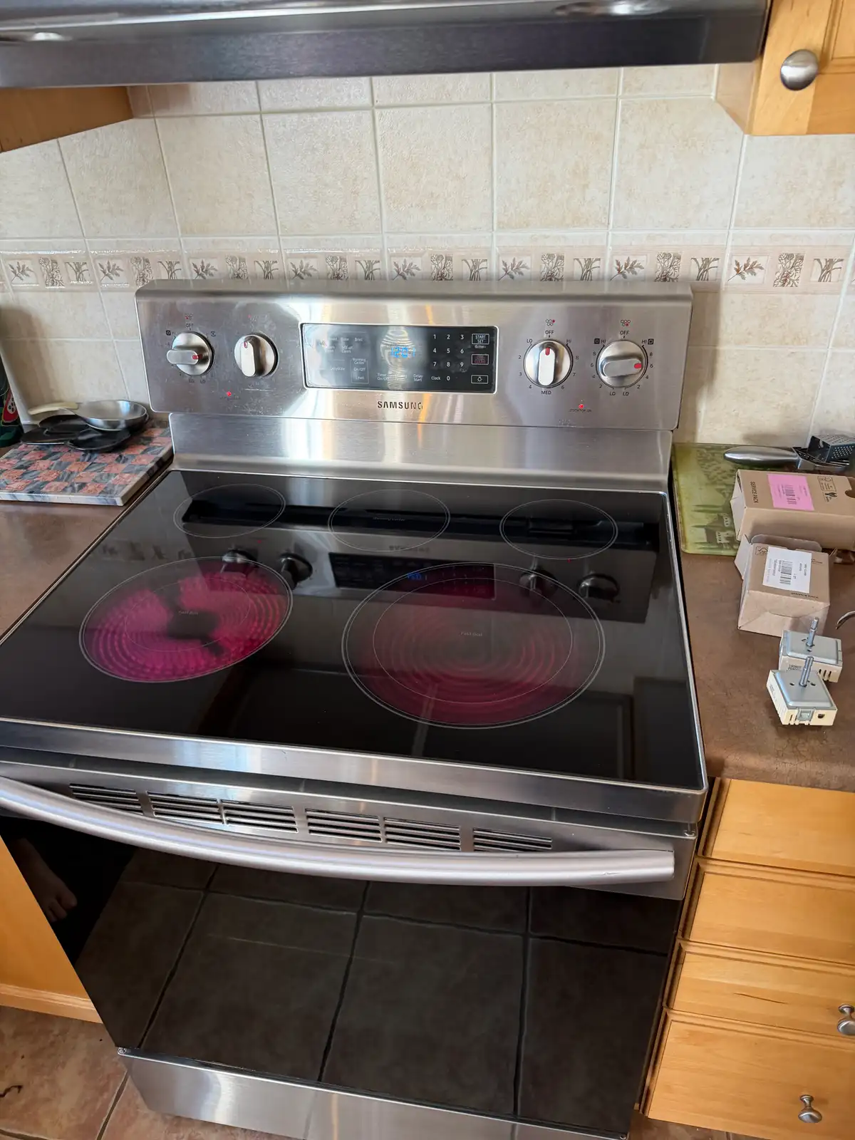 Samsung electric range with glowing cooktop burners during repair in Ottawa