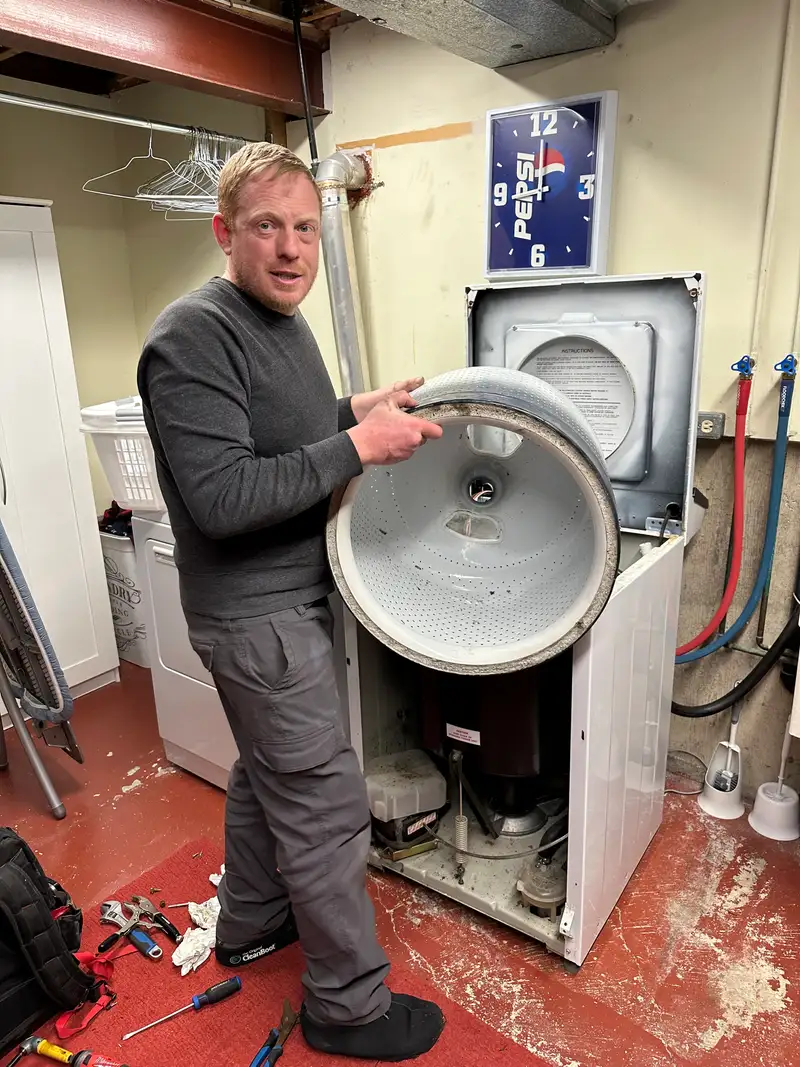 Technician holding a washer drum removed during repair in Ottawa