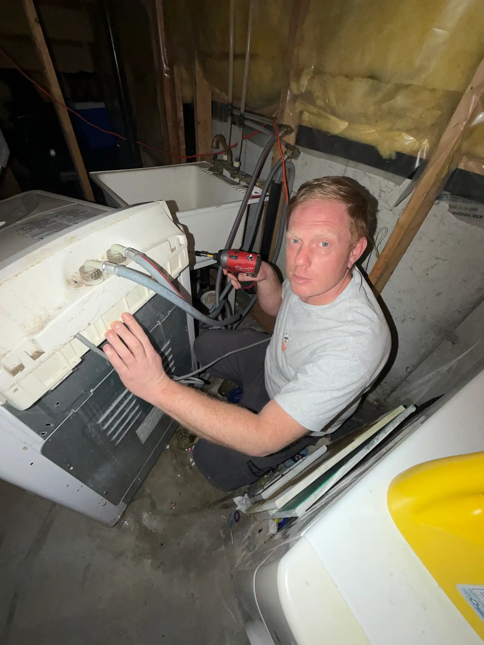 Technician servicing a washer in an Ottawa basement