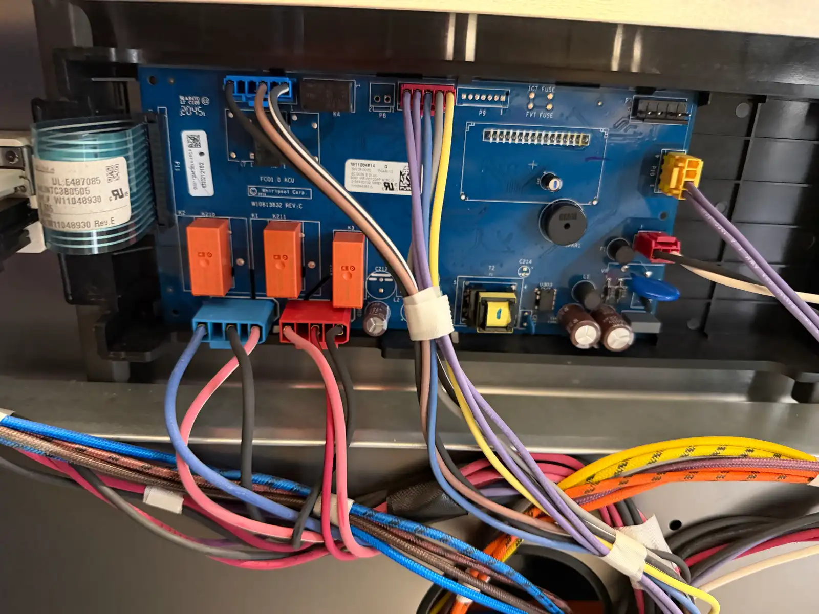 Close-up of a Whirlpool stove control board and wiring during repair